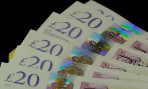 Kilka banknotów 20 funtów aktualnych, ułożonych w wachlarz. Widać holograficzne korony i napisy.