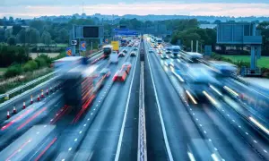 Autostrada w Wielkiej Brytanii, ruchliwy dzień. Wiele samochodów i ciężarówek w ruchu, tworząc smugi światła.