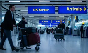 Na lotnisku w UK, podróżni z bagażami kierują się do odprawy. Zastanawiasz się, ile alkoholu do UK możesz przywieźć?