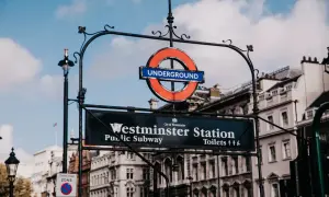 Znak Westminster Station, ikona metra londyn ceny. Klasyczny okrągły symbol "Underground" nad tablicą z nazwą stacji i informacją o toaletach.