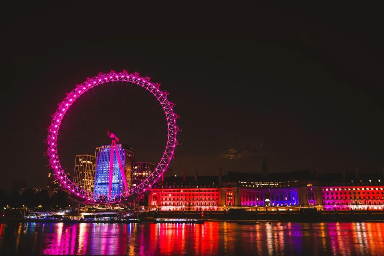 Londyn nocą: London Eye i oświetlone budynki nad Tamizą. Te **anglia zabytki** lśnią w kolorach, tworząc magiczny widok.