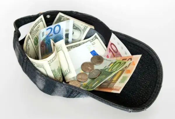 Dolarów i euro w czapce, jakby to był cały majątek z zagranicznego konta bankowego.